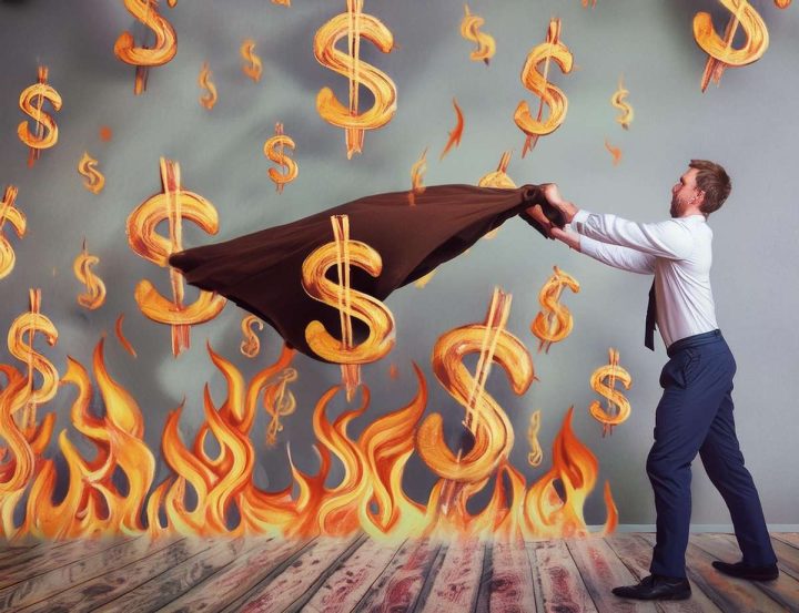 Firefly man throwing blanket over a fire represented by dollar signs, a metaphor for increasing infl